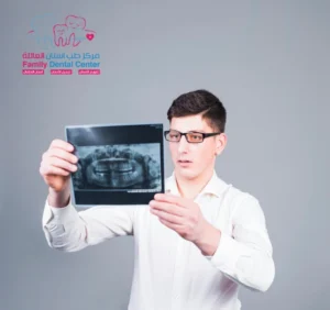 A dentist in a white coat carefully examines dental X-rays to assess potential negative effects of dental implants."